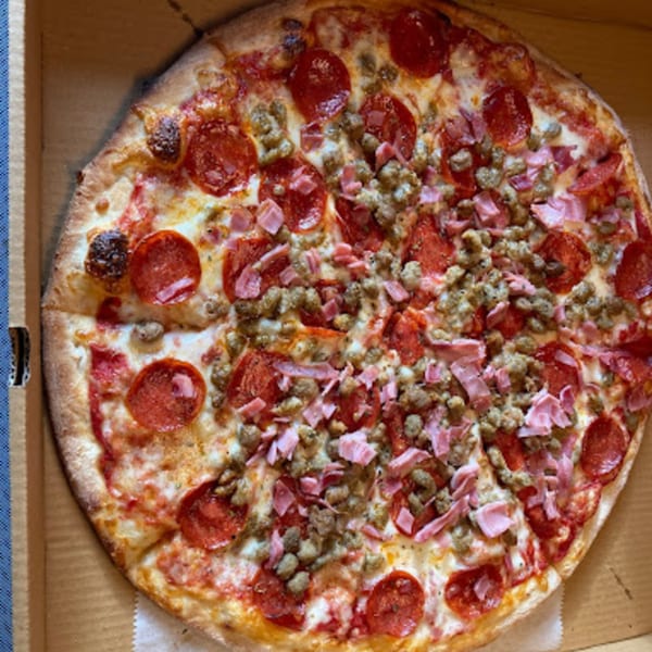 A whole Lorenzo's Pizza with pepperoni, sausage, and ham in a cardboard box.