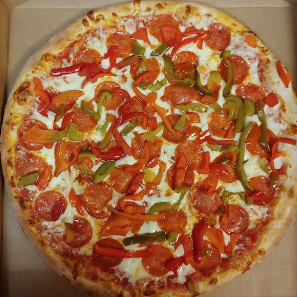 A whole Lorenzo's Pizza with pepperoni, red and green bell peppers, and melted cheese in a box.